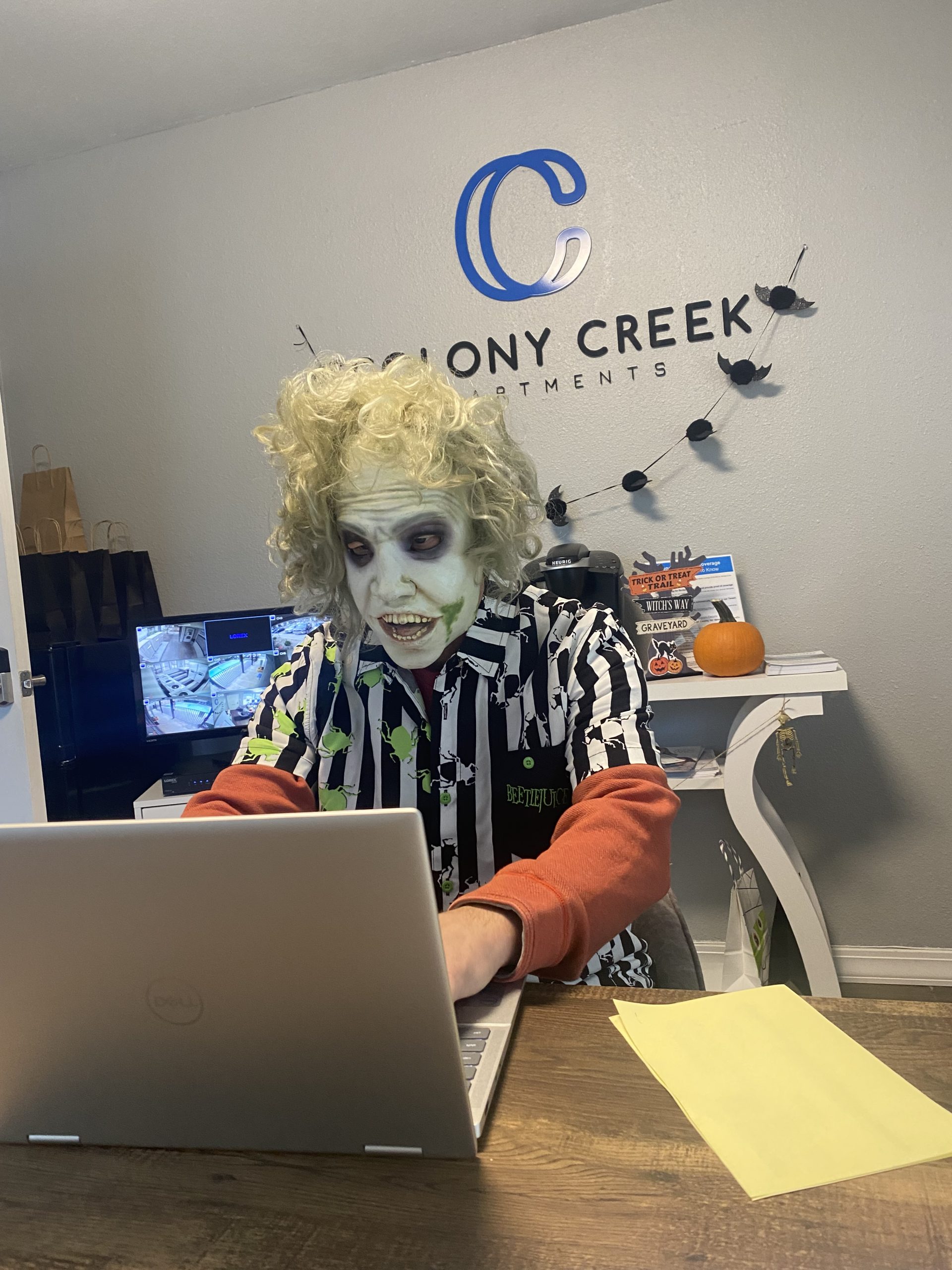 a man in a costume sitting at a laptop at The Colony Creek Apartments